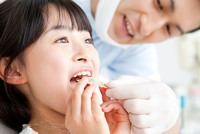 リテーナーを口に入れる子供